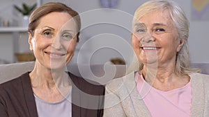 Cheerful aged women smiling at camera, dental implants, healthy teeth, care