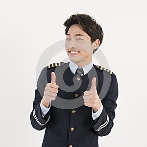 Cheerful airline pilot wearing uniform with thumb up gesture of approval