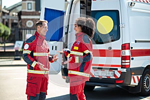 Cheerful ambulance doctors having a conversation outdoors