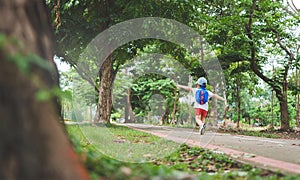 Cheerful Asian boy running to school