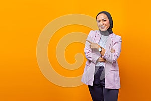 Cheerful Asian business woman pointing fingers to empty space over yellow background photo