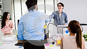 Cheerful Asian businessman partners making fist bump with a smile as a symbol of teamwork. Positive multi-ethnic business