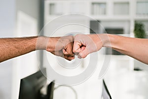 Cheerful Asian businessman partners making fist bump with a smile as a symbol of teamwork. Positive multi-ethnic business