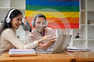 A cheerful Asian gay enjoys reading comments online while streaming live podcasts with colleague