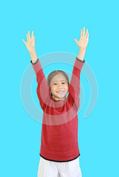 Cheerful asian little kid girl in red long sleeve shirt holding hands up isolated on cyan background. Student question and answer