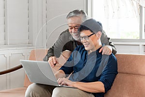 Cheerful asian middle aged son and senior father in living room, Happiness Asian family concepts