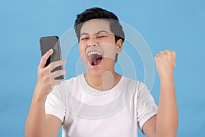 Cheerful Asian people are holding their smartphones. Isolated on a light blue background in the studio