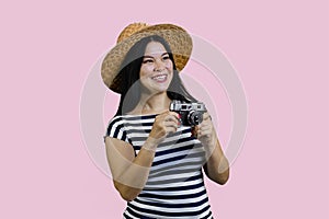 Cheerful asian tourist woman with a vintage photo camera.