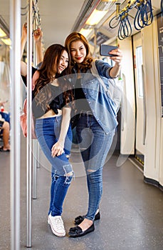 Cheerful Asian woman standing on platform at railway station