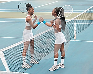 Cheerful athletes celebrate on the tennis court. Two friends holding hands over the net on the tennis court. Young women