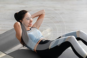 Cheerful athletic lady doing crunches at home