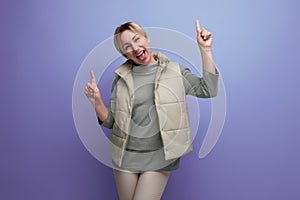 cheerful attractive blond young woman smiling at camera on studio background