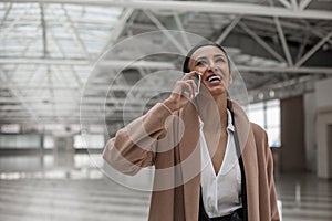 Cheerful attractive female is talking on smartphone