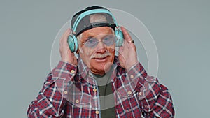 Cheerful attractive man listening music via headphones and dancing disco fooling around having fun