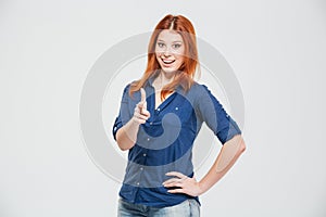 Cheerful attractive redhead young woman pointing on you