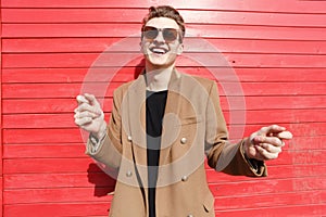 Cheerful attractive young man in sunglasses laughing and having fun