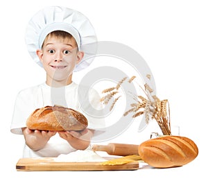 Cheerful baker boy with a loaf of rye bread