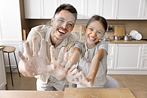 Cheerful baker dad and laughing daughter child having fun together