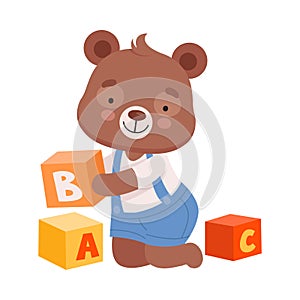 Cheerful Bear Character Wearing Playsuit Sitting on the Floor and Playing Alphabet Cubes Vector Illustration photo