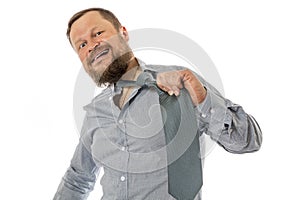 Cheerful bearded man dressed in shirt rips off his tie