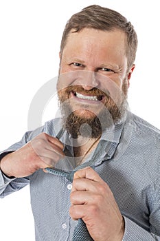 Cheerful bearded man dressed in shirt rips off his tie