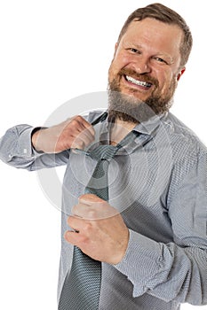 Cheerful bearded man dressed in shirt rips off his tie