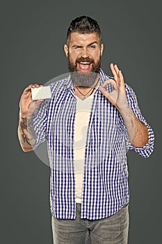 cheerful bearded man showing blank debit card with copy space