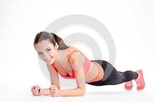 Cheerful beautiful fitness woman doing plank exercise