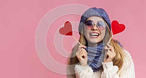 Cheerful beautiful girl in eyewear holding valentine cards