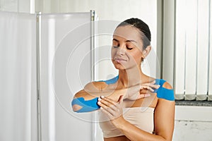 cheerful beautiful woman with kinesiological tapes