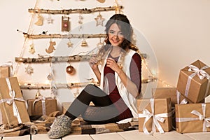 Cheerful beautiful woman open the Christmas present over white backgound. New Year 2020