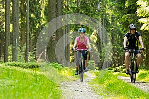 Cheerful biker couple in woods