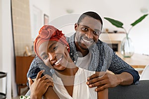 Cheerful black couple embracing at home