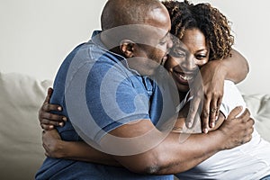 A cheerful black couple hugging each other