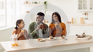 Cheerful Black Family Having Lunch Sitting In Kitchen, Panorama