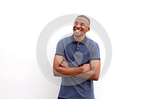 Cheerful black guy with arms crossed and looking away against white background