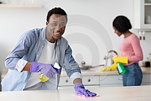 Cheerful black guy and lady cleaning their new house