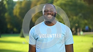 Cheerful black male eco-volunteer smiling to camera, nature preservation project