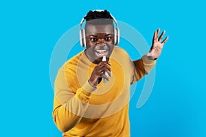 Cheerful Black Man Wearing Wireless Headphones Listening Music And Singing