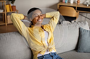 Cheerful Black Millennial Lady Resting Sitting On Couch At Home