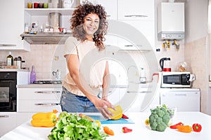Cheerful black woman cooking at home looking a the camera