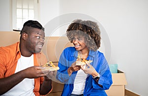 Cheerful Black Young Couple Eating Pizza Together On Moving Day