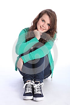 Cheerful blue eyed teenager girl relaxed on floor