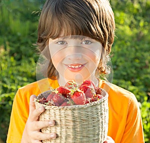 Cheerful boy with a basket of berries