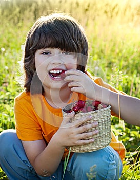 cheerful boy with a basket of berries