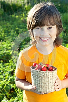 Cheerful boy with a basket of berries