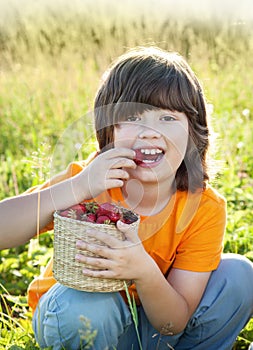 Cheerful boy with a basket of berries