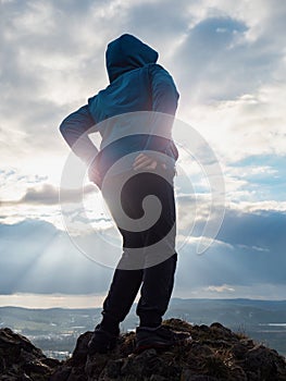 Cheerful boy is grimacing on top of the mountain where he climbed photo