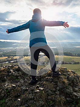 Cheerful boy is grimacing on top of the mountain where he climbed photo
