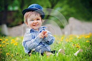 cheerful boy with hat in summer park